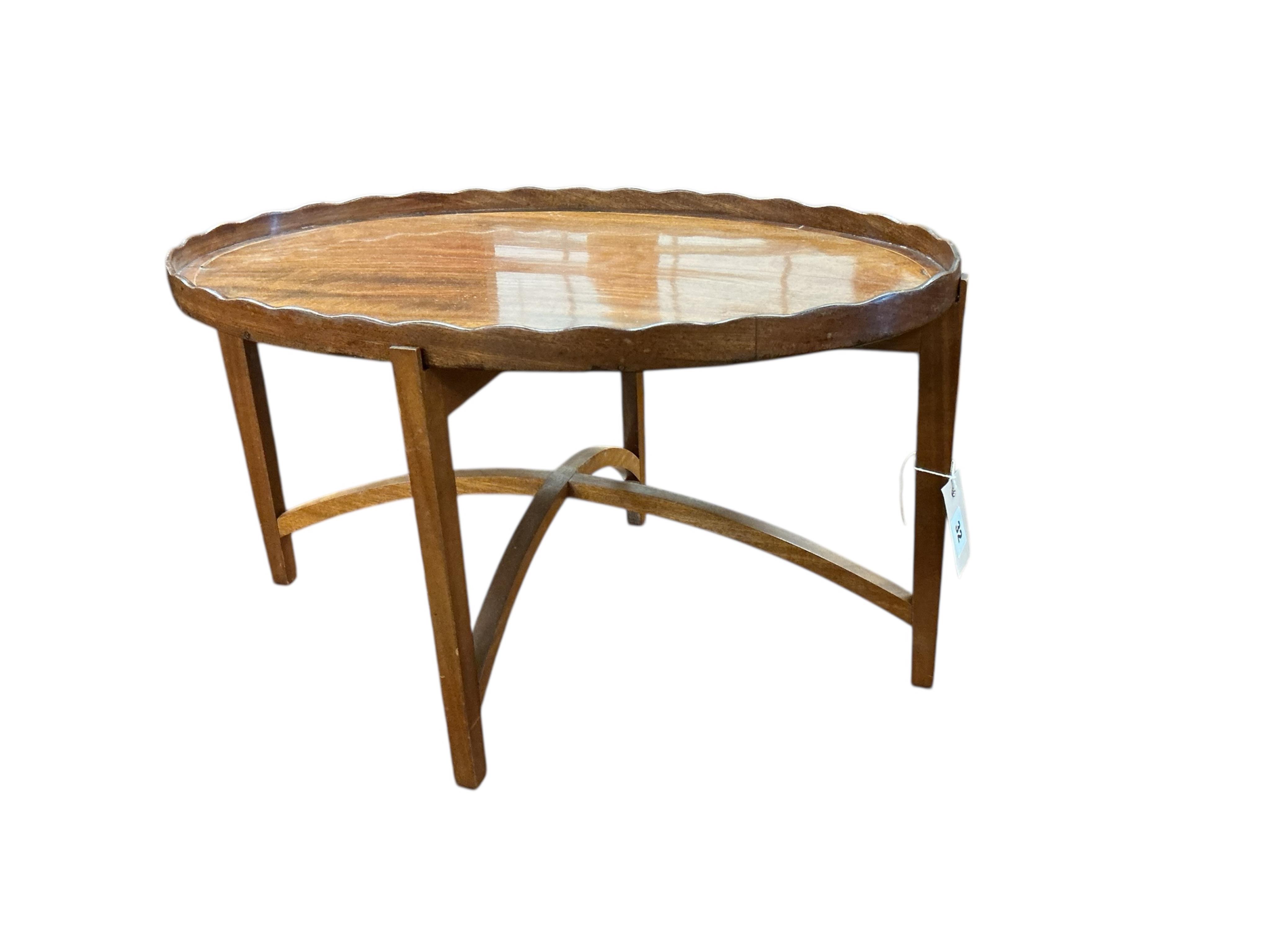 A George III oval mahogany tea tray on later stand, width 58cm, depth 39cm, height 33cm